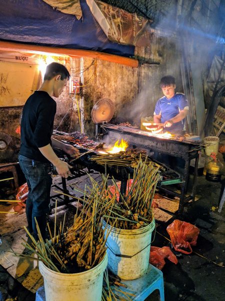 Man cooking barbecue along street