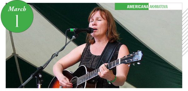 Iris DeMent singing onstage with guitar
