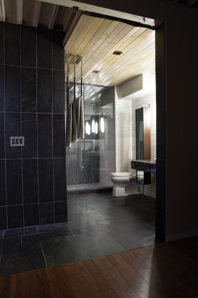 Gray slate tile, a marble sink, and wood planks on the ceiling lend a spa feel to the master bath.