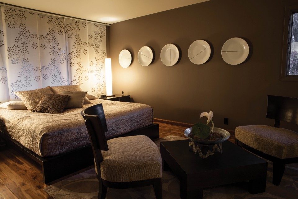 White decorative plates that Darcy bought on clearance are used in a bedroom as wall art.